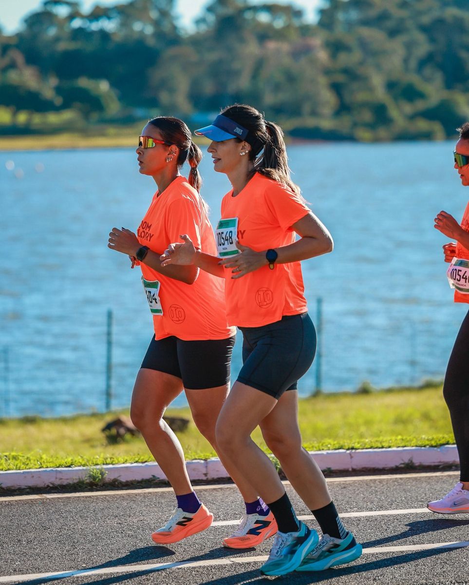 Dra. Nádia Côrtes correndo com uma amiga à beira do lago